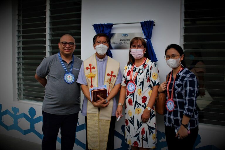 Allan Santos, Dr. Minerva Serafica, and Geraldine Escano posed with Rev. Fr. Jose Laforteza after the classrooms’ blessing.